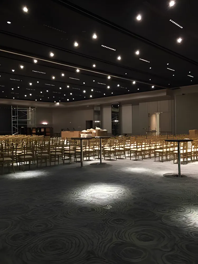 Ballroom montado con mesas redondas, en penumbra