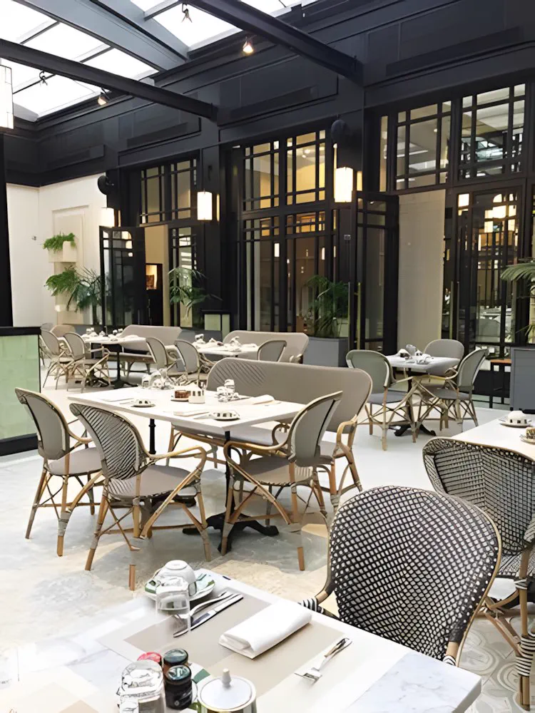Restaurante bajo el techo vidriado, con las mesas puestas