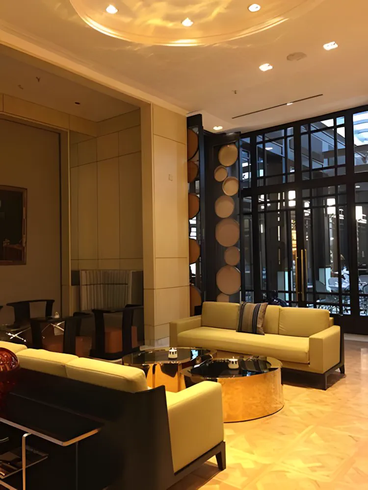 Lobby con sillones y la fachada vidriada al fondo