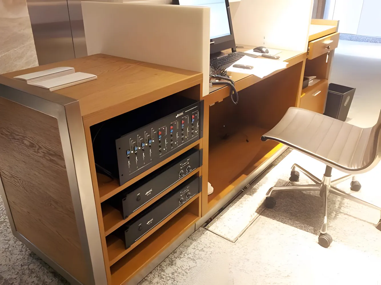 Rack de audio integrado en un mueble de madera, junto al puesto de trabajo