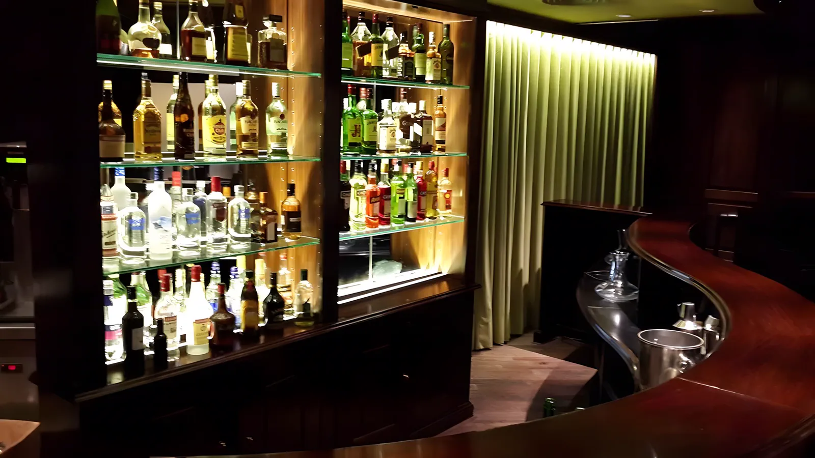 Barra del bar, con las botellas iluminadas por detrás