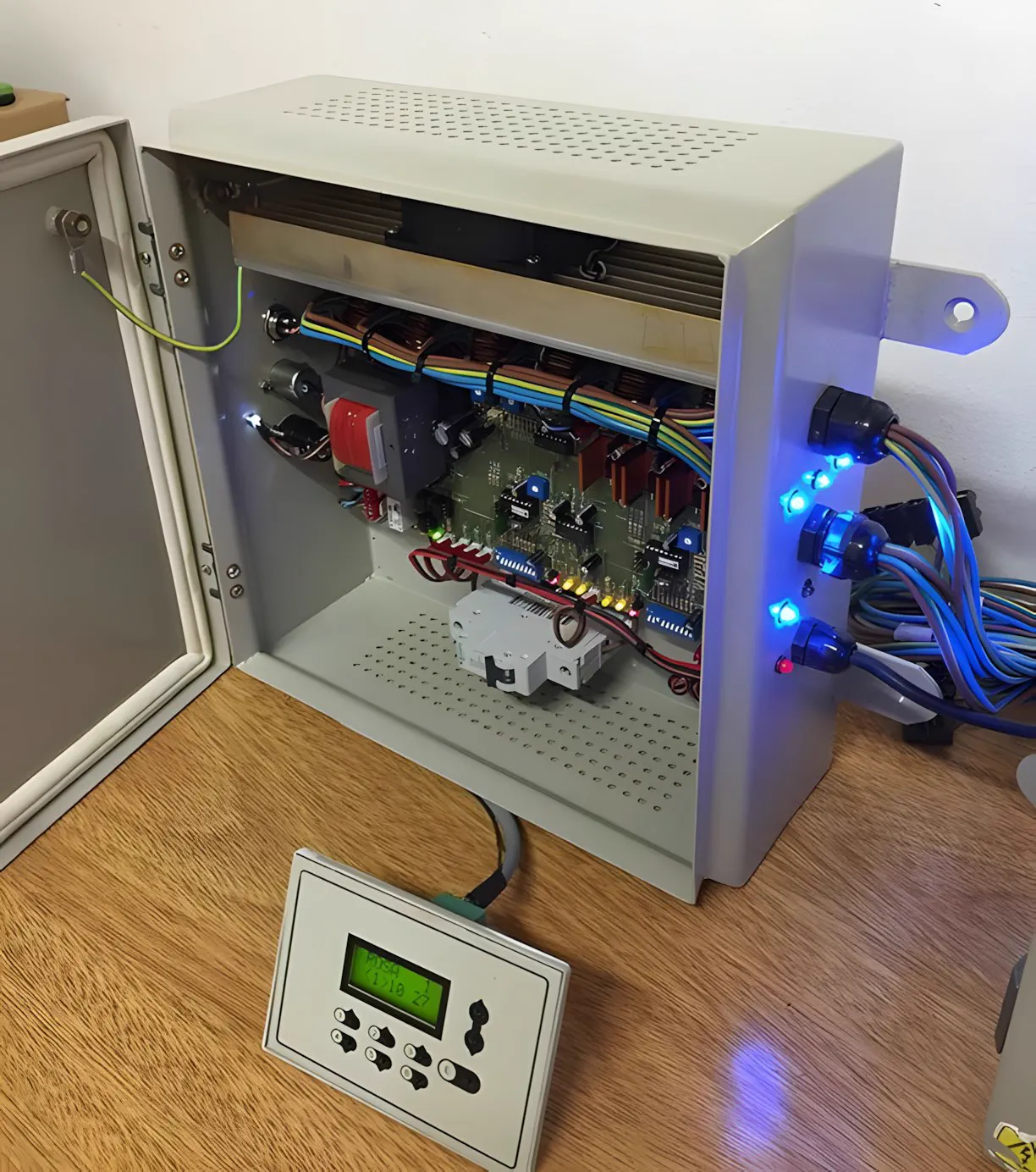 Tablero de control de iluminación abierto, con el cableado y el keypad al frente