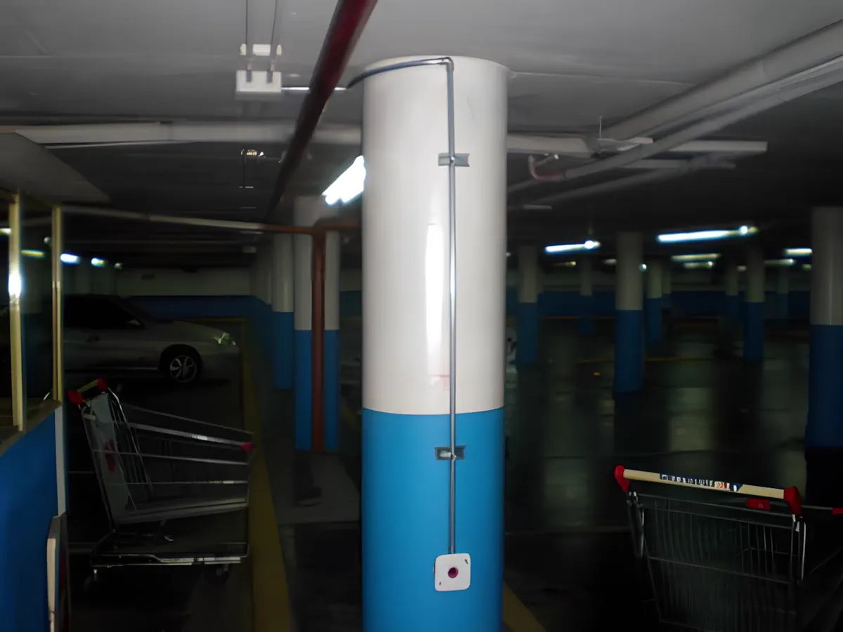 Estacionamiento cubierto de la sucursal, con la bajada de audio sobre una columna