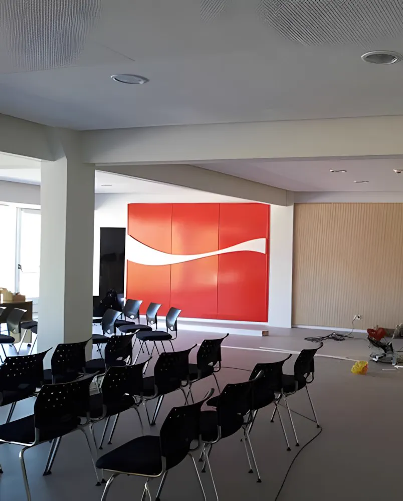Sala de capacitación montada con sillas, frente al panel del fondo
