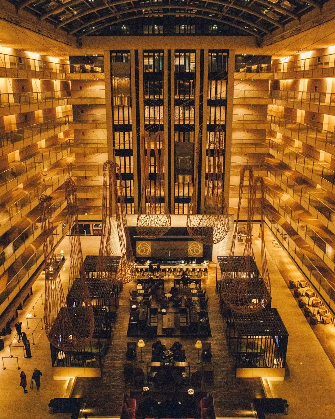 Atrio del Hotel Hilton Buenos Aires visto desde arriba, con los pisos iluminados y el lobby al fondo