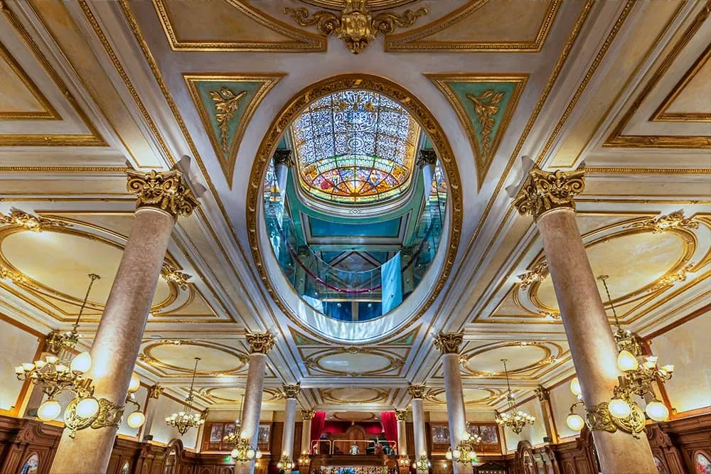 Salón de la Confitería La Ideal, con las columnas, las arañas y la cúpula vidriada sobre el óvalo del cielorraso