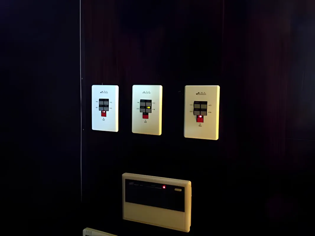 Tres teclados de escena y un panel iluminados sobre la pared oscura del salón