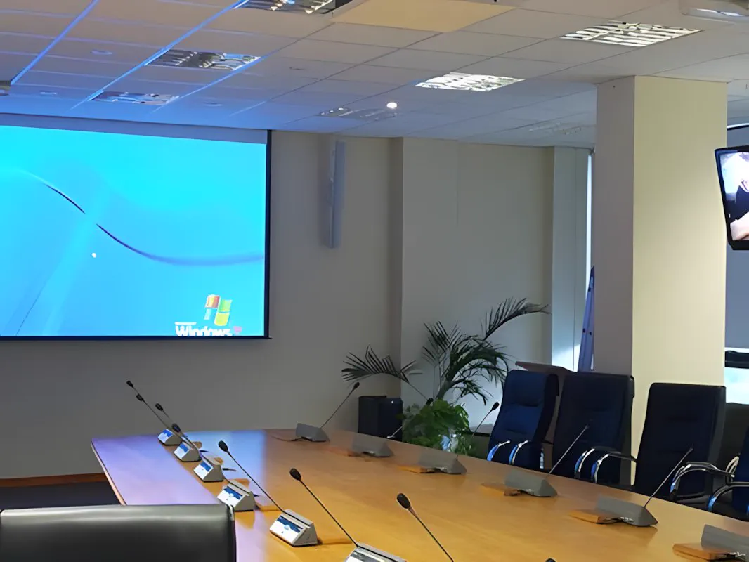 La pantalla de proyección bajada sobre el frente de la sala