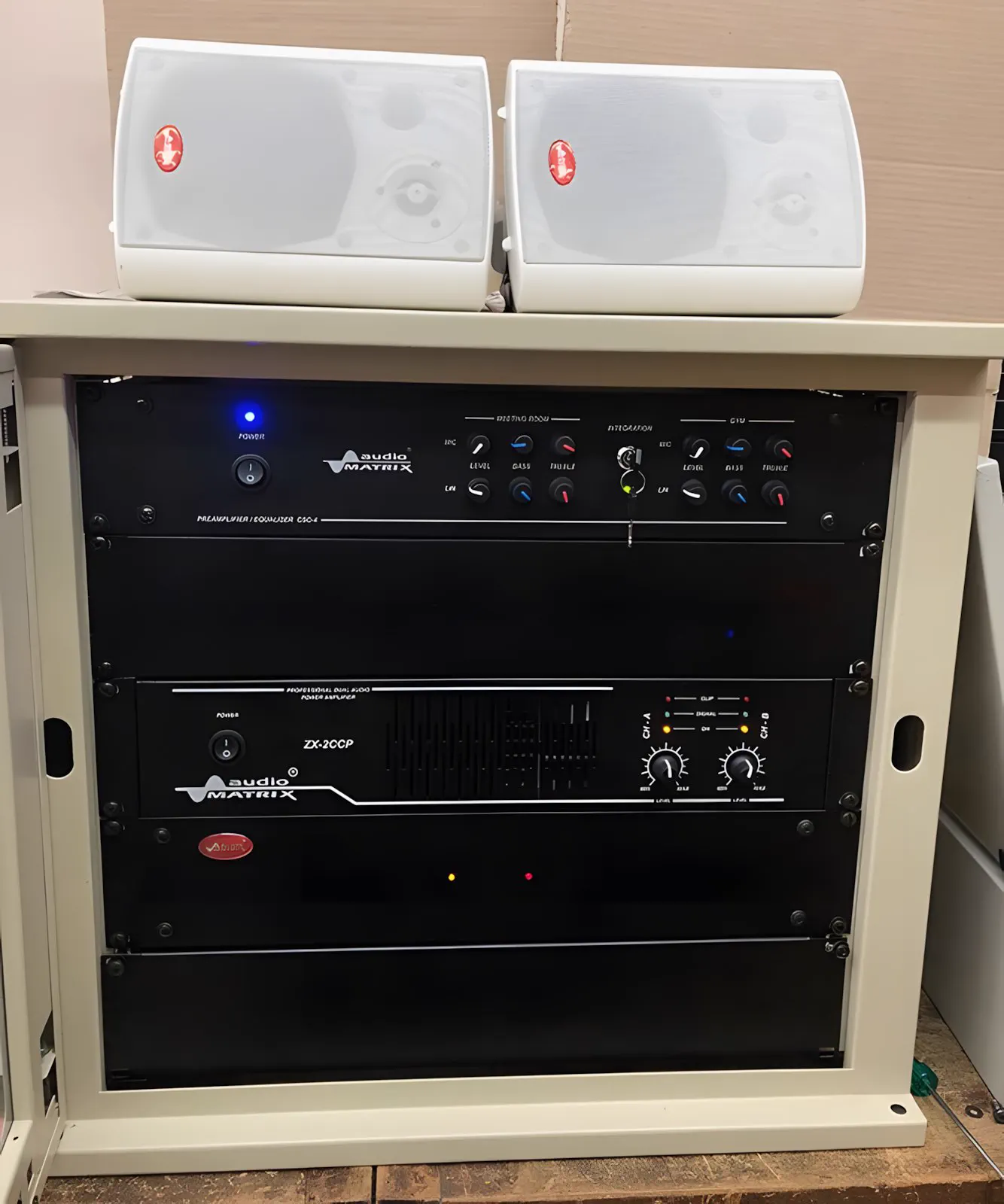 Rack abierto con el amplificador encendido y los parlantes arriba