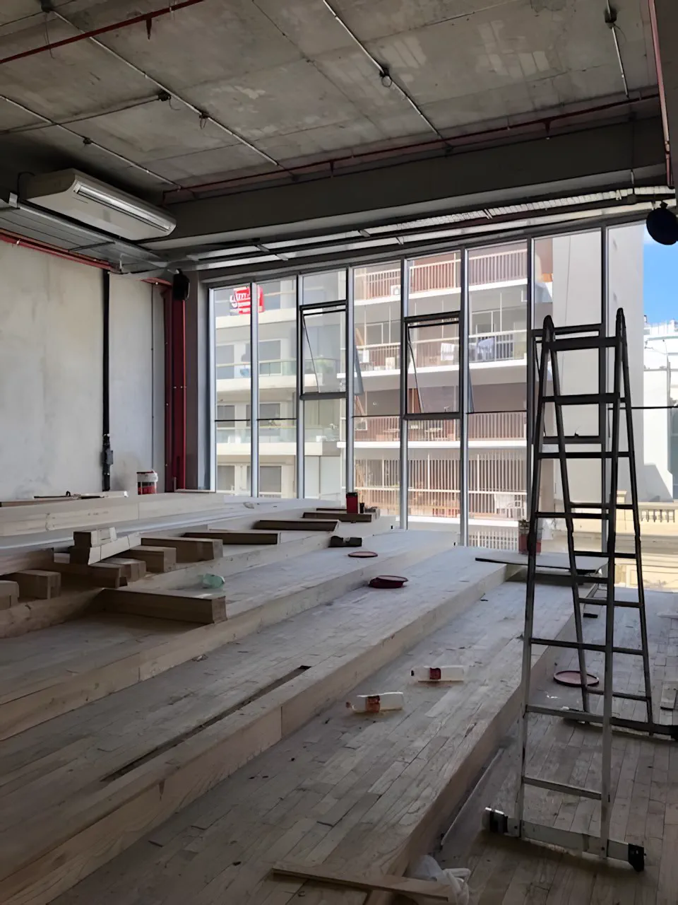 Gimnasio en obra, con el piso de madera en montaje