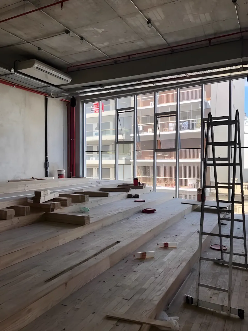 Otra vista del gimnasio en obra, con los ventanales y el piso en montaje