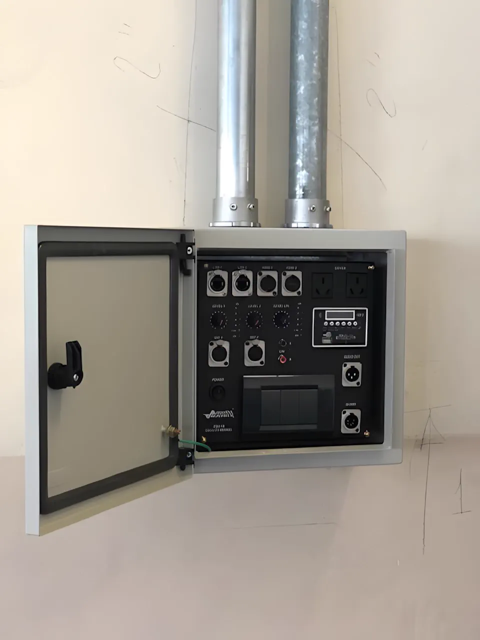 Gabinete de pared abierto, con el panel de conexiones y la bajada de caño