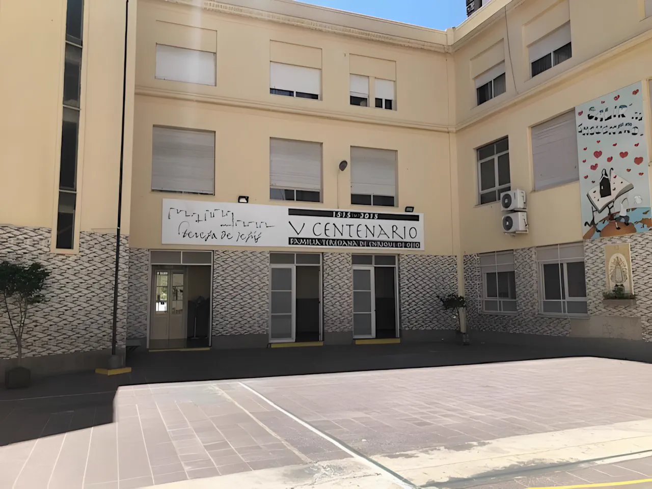 Patio descubierto del colegio, con el edificio de aulas al fondo