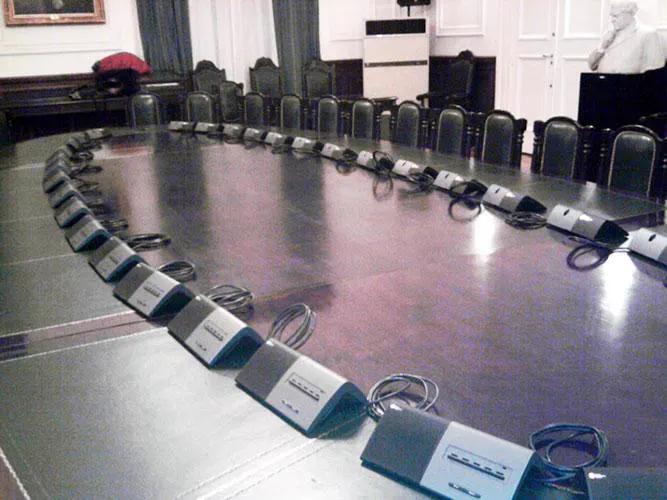 Sala de conferencias de la UBA con consolas de interpretación en cada puesto
