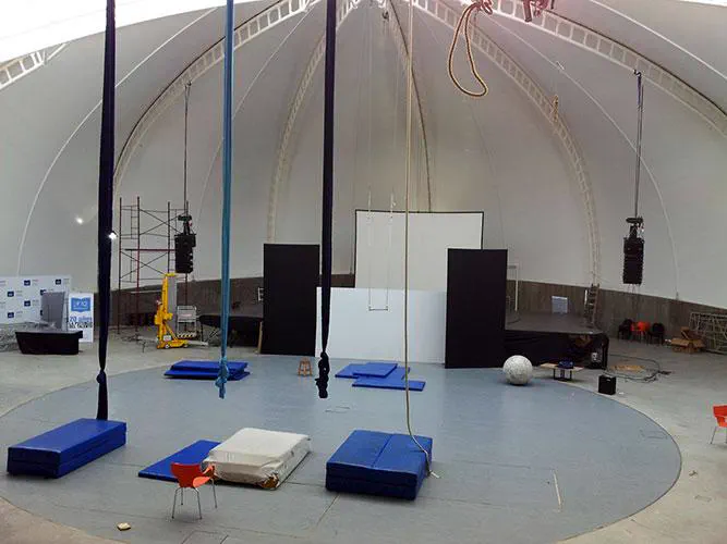 Sala abovedada de la UNSAM con line array colgado sobre el escenario