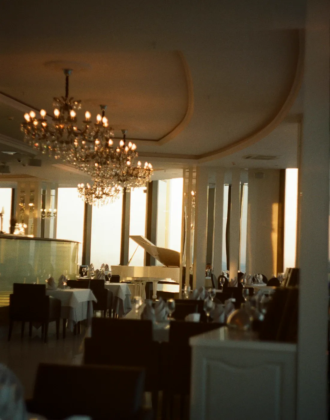 Comedor de hotel con arañas de cristal y piano de cola